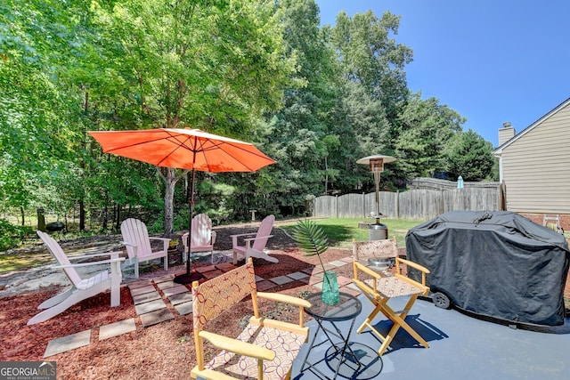 view of patio with area for grilling and a fire pit