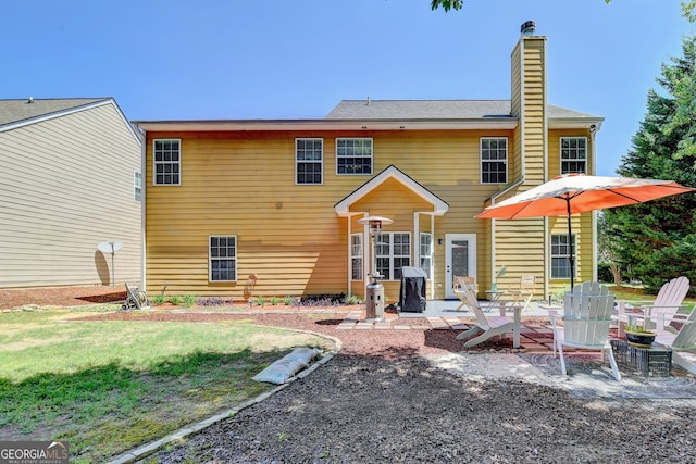 rear view of house with a yard and a patio