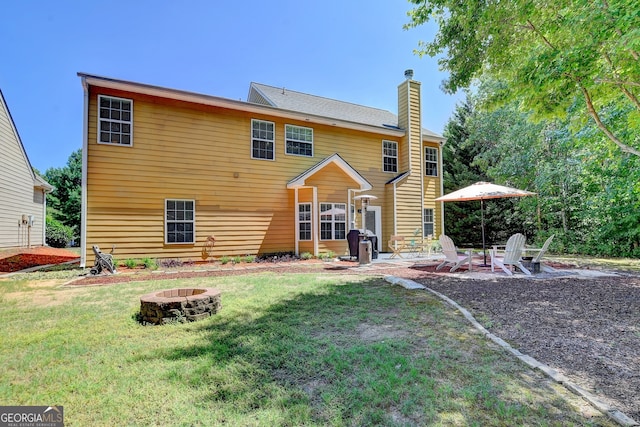 rear view of house featuring an outdoor fire pit, a patio area, and a lawn