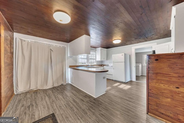 kitchen with white cabinetry, white refrigerator, washer / dryer, and dark wood-type flooring