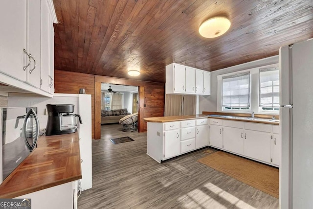 kitchen with white refrigerator, wooden ceiling, white cabinets, and dark hardwood / wood-style flooring