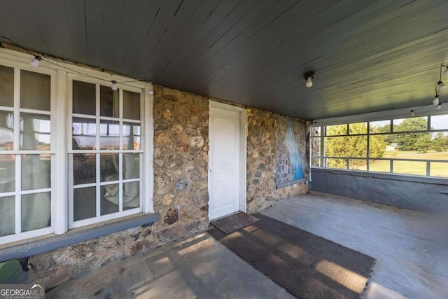 unfurnished sunroom with wood ceiling