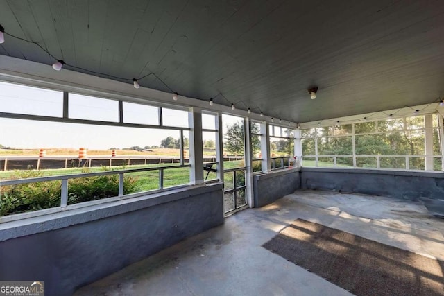 unfurnished sunroom with wooden ceiling and a rural view