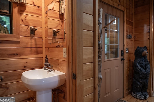 bathroom featuring sink and wooden walls