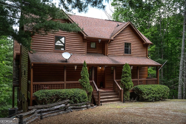 log-style house featuring a porch and central AC