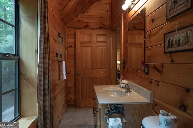 bathroom with tile patterned floors, vanity, wood walls, and toilet