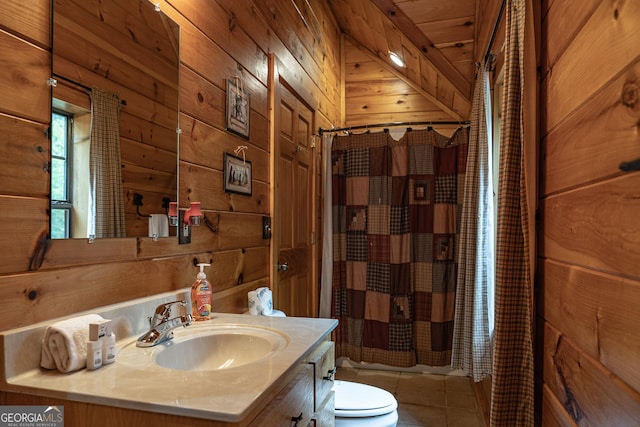 bathroom featuring toilet, vanity, wooden walls, and tile patterned flooring