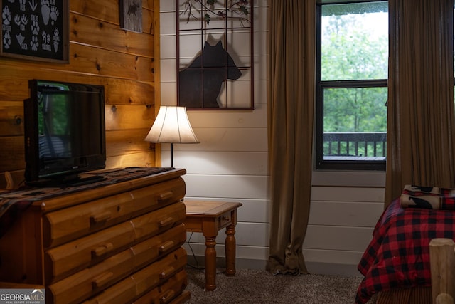 bedroom with carpet flooring and wooden walls