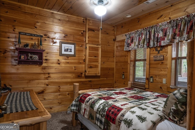 bedroom with multiple windows, carpet flooring, wood ceiling, and wood walls