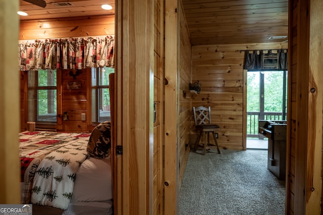 carpeted bedroom featuring wood walls, access to exterior, and wood ceiling