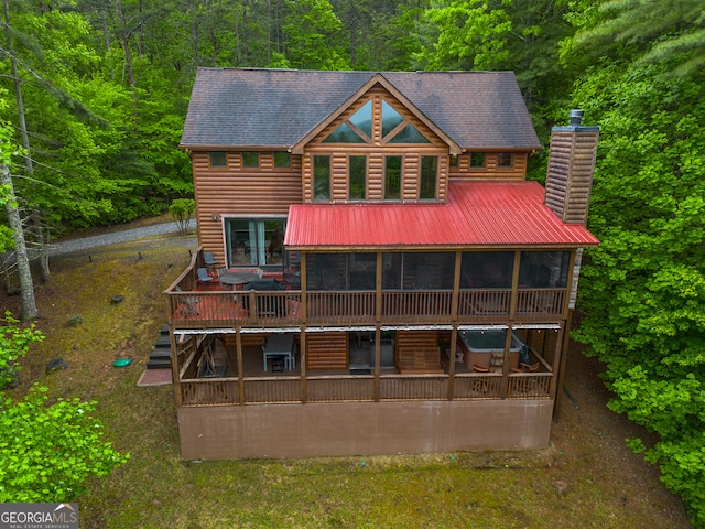 rear view of property with a sunroom and a wooden deck