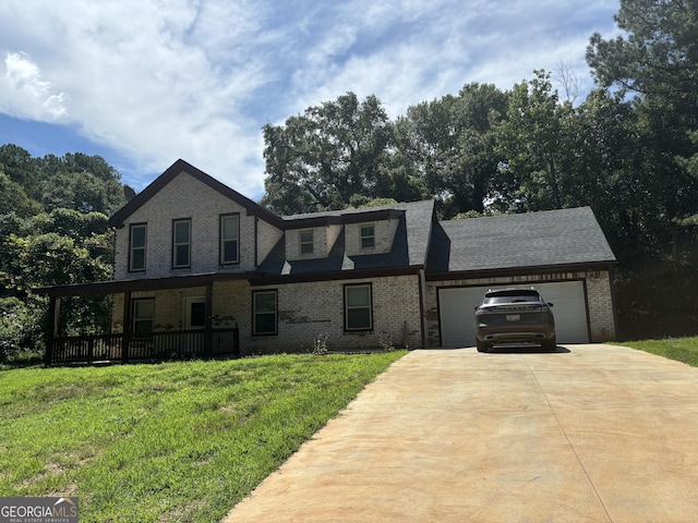 view of front of house featuring covered porch, a garage, and a front lawn