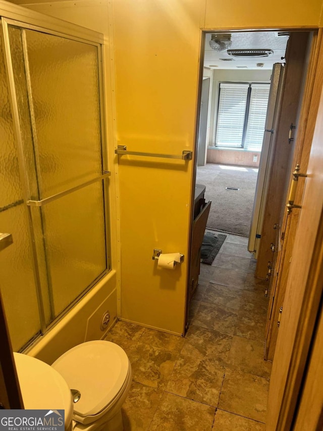 full bathroom with vanity, shower / bath combination with glass door, toilet, and tile patterned flooring