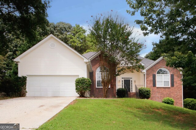 view of front of house featuring a garage and a front lawn