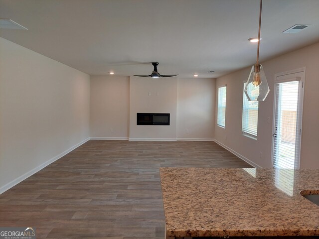 unfurnished living room featuring hardwood / wood-style flooring and ceiling fan