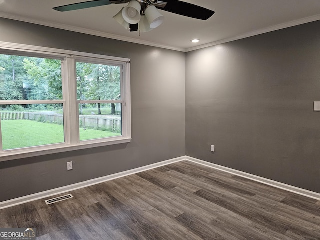 spare room featuring ornamental molding and dark hardwood / wood-style flooring