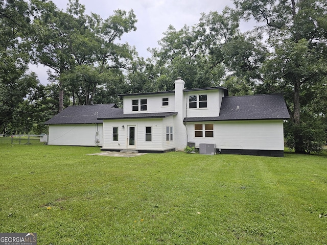 rear view of property featuring a patio and a lawn