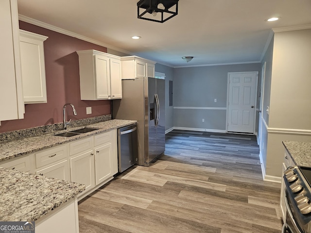 kitchen with light stone counters, sink, white cabinets, and appliances with stainless steel finishes