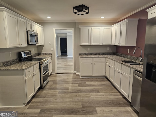 kitchen featuring appliances with stainless steel finishes, dark stone countertops, and white cabinets