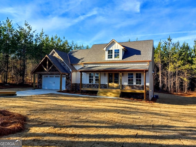 view of front of property with a garage, covered porch, and a front lawn