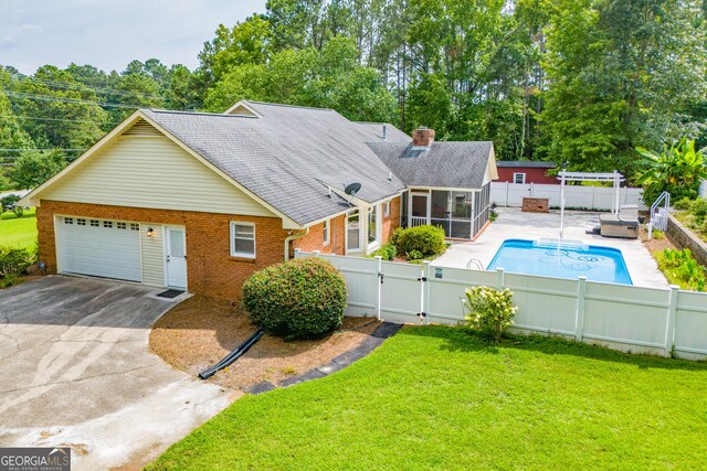 exterior space featuring a patio area, a sunroom, and a yard