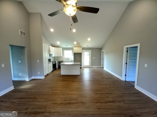 kitchen featuring dark wood-type flooring, black range with electric cooktop, a center island, white cabinets, and high vaulted ceiling