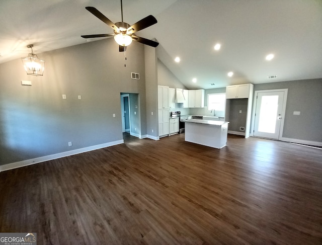 unfurnished living room featuring lofted ceiling, dark wood-type flooring, ceiling fan with notable chandelier, and sink