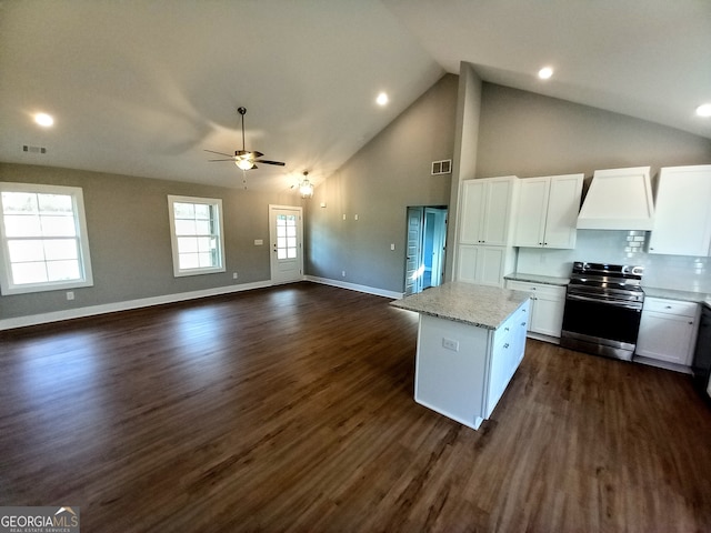 kitchen featuring white cabinets, dark hardwood / wood-style floors, electric range, and a kitchen island