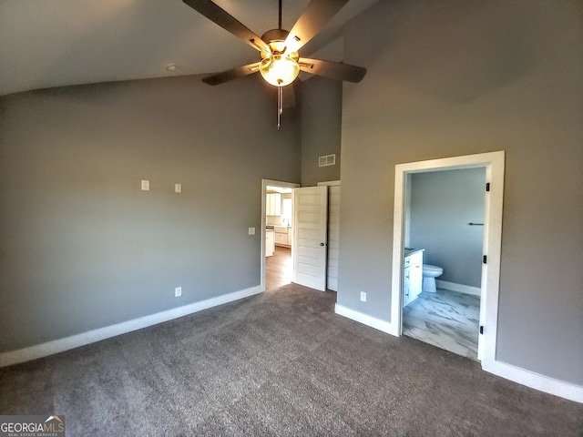 unfurnished bedroom with connected bathroom, ceiling fan, high vaulted ceiling, and dark carpet