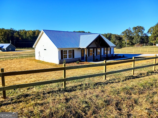 view of front facade with a rural view