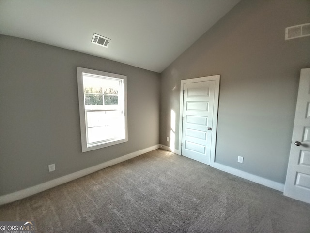 unfurnished bedroom featuring carpet flooring and lofted ceiling