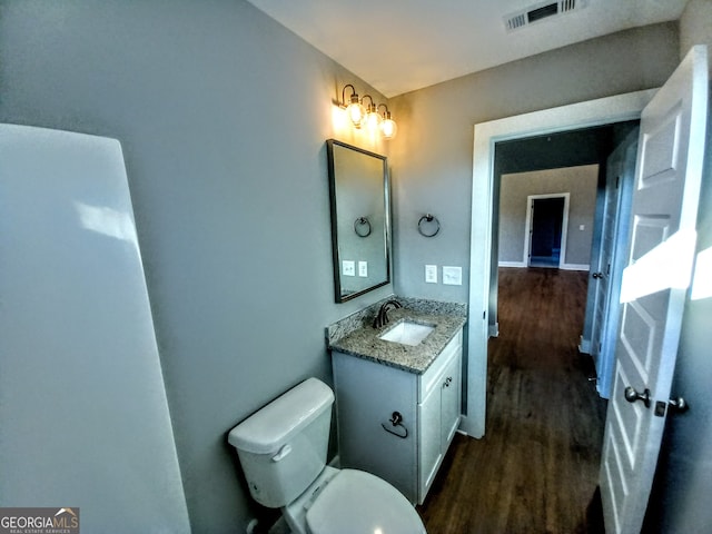 bathroom with vanity, toilet, and wood-type flooring