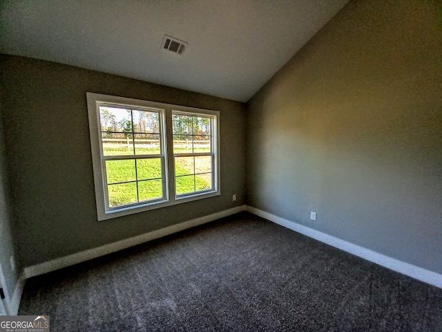 carpeted empty room with vaulted ceiling