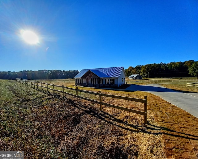 view of yard with a rural view and an outdoor structure