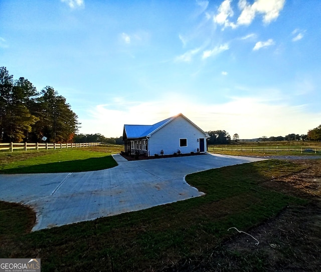 exterior space featuring a lawn and a rural view