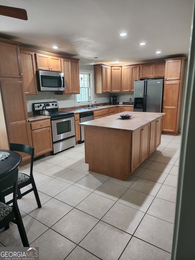 kitchen featuring sink, stainless steel appliances, a center island, and light tile patterned flooring