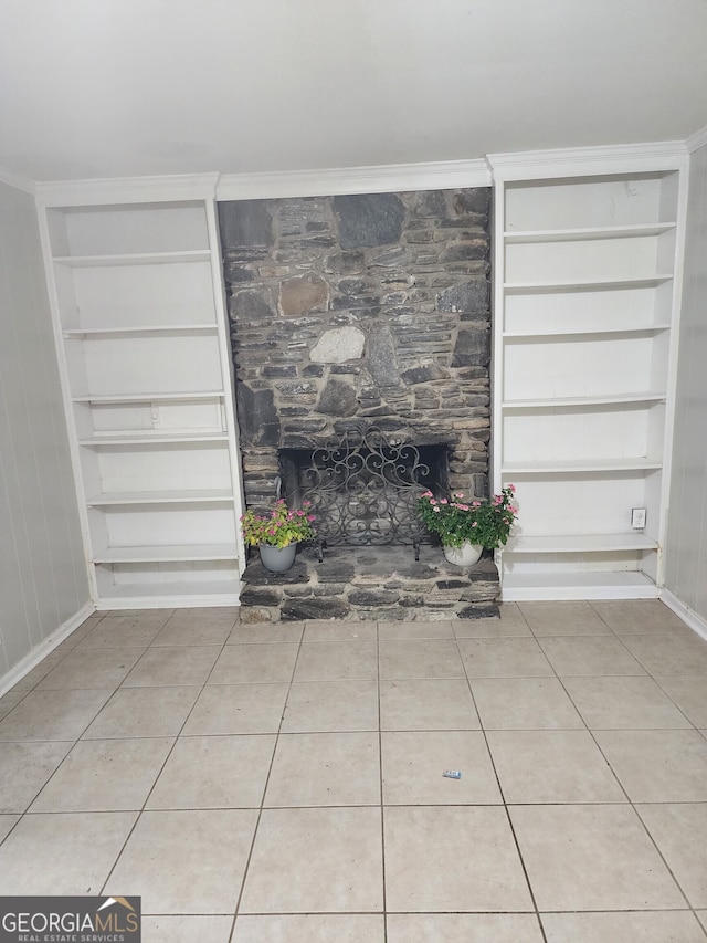 unfurnished living room with built in shelves, a fireplace, and light tile patterned floors