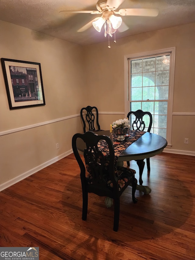 dining space featuring ceiling fan, a textured ceiling, and dark hardwood / wood-style flooring