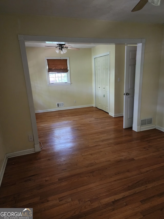 unfurnished bedroom featuring dark hardwood / wood-style floors and ceiling fan