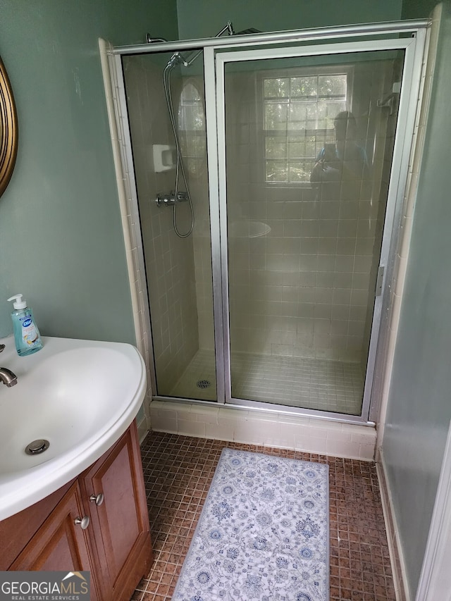 bathroom featuring vanity, a shower with shower door, and tile patterned floors