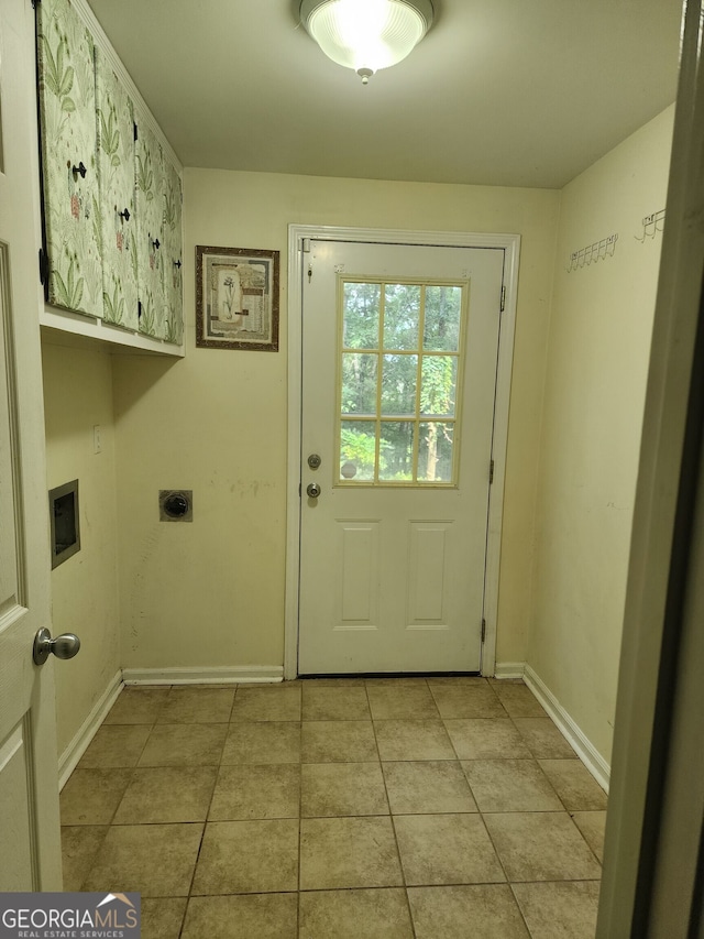 clothes washing area with light tile patterned floors, cabinets, and hookup for an electric dryer