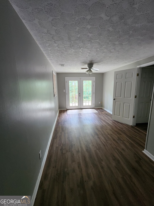 unfurnished room with french doors, dark hardwood / wood-style floors, a textured ceiling, and ceiling fan