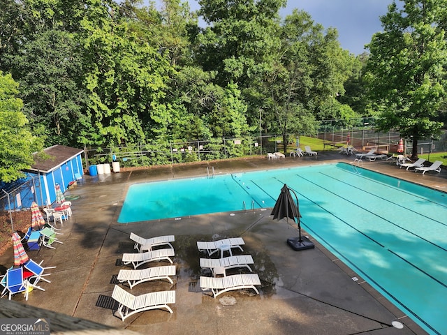 view of pool with a storage unit and a patio area