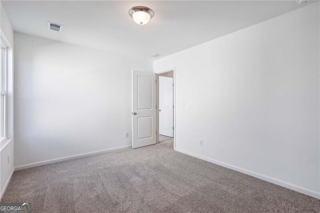 spare room featuring dark colored carpet