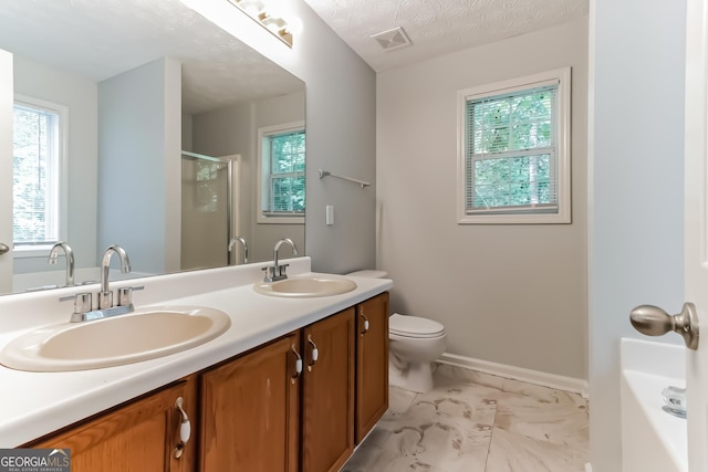 bathroom with vanity, a wealth of natural light, a textured ceiling, and toilet