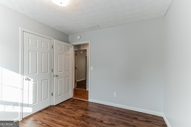 unfurnished bedroom with wood-type flooring and a textured ceiling