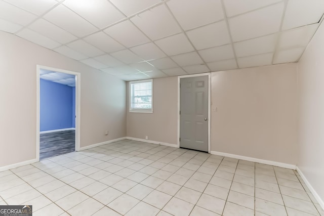 unfurnished room featuring a drop ceiling