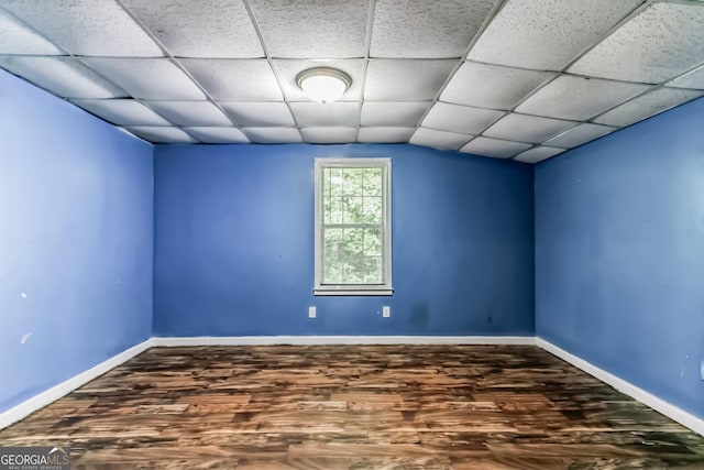 empty room featuring dark hardwood / wood-style floors and a paneled ceiling