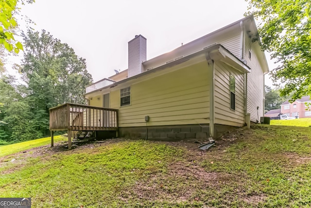 back of house featuring a deck and a lawn