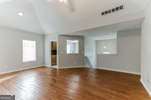 unfurnished living room featuring hardwood / wood-style flooring, lofted ceiling, and ceiling fan